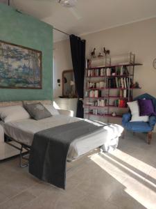 1 dormitorio con 1 cama y 1 silla en La Ca' Affittacamere, en Matino