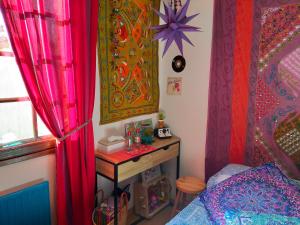 um quarto com uma cama, uma mesa e cortinas em Les chambres de la casa d'Elena em Cholet