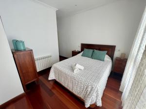 a bedroom with a bed with two towels on it at Gran piso luminoso de 125 m2 en el centro de Leon in León