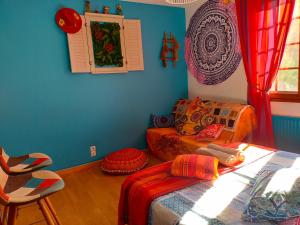 a room with a bed and a couch and a chair at Les chambres de la casa d'Elena in Cholet