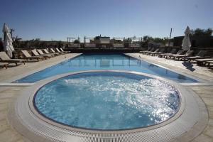 a large swimming pool with lounge chairs in a resort at Selina Desert Garden Ramon in Mitzpe Ramon