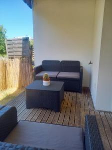 une terrasse avec deux chaises, un canapé et une table dans l'établissement Cocon reposant à 10min du centre de Bordeaux, à Lormont