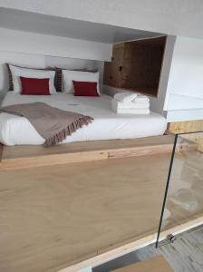 1 dormitorio con 1 cama grande con almohadas rojas en 7 Trevos Houses A, en Santiago do Cacém