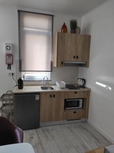 a kitchen with wooden cabinets and a sink at 7 Trevos Houses A in Santiago do Cacém