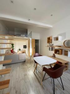 a living room with a table and chairs and a couch at 7 Trevos Houses A in Santiago do Cacém