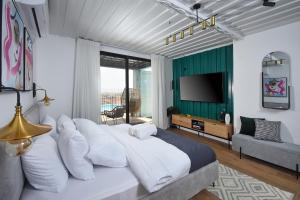 een slaapkamer met een groot bed en een televisie bij The Container luxury holiday resort for Couples in Yavneʼel