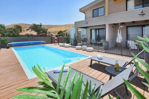 een huis met een zwembad op een houten terras bij The Container luxury holiday resort for Couples in Yavneʼel