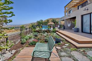 una sedia verde appoggiata su un ponte di fronte a una casa di The Container luxury holiday resort a Yavneʼel