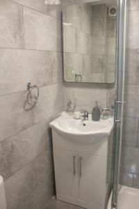 y baño con lavabo, espejo y ducha. en Charming Accommodation close to Birmingham en West Bromwich