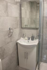 a bathroom with a sink and a mirror and a shower at Charming Accommodation close to Birmingham in West Bromwich