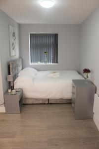 a bedroom with a large white bed with a window at Charming Accommodation close to Birmingham in West Bromwich