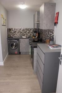 a kitchen with a stove and a washing machine at Charming Accommodation close to Birmingham in West Bromwich
