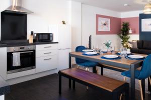 a kitchen and living room with a table and chairs at Glevum Lodge - 2 Bedroom Town Centre Apartment in Cirencester