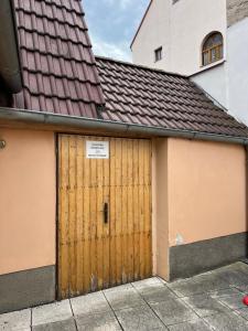 a garage with two wooden doors and a building at Celý dům v historickém centru Loun in Louny