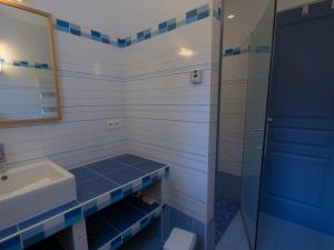 een blauwe en witte badkamer met een wastafel en een spiegel bij Maison Bangor, 5 pièces, 8 personnes - FR-1-418-6 in Bangor