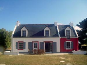 een rood-wit huis met een tafel ervoor bij Maison Bangor, 5 pièces, 8 personnes - FR-1-418-6 in Bangor