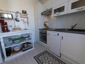 a small kitchen with white cabinets and a sink at Appartement Le Palais, 3 pièces, 4 personnes - FR-1-418-80 in Le Palais