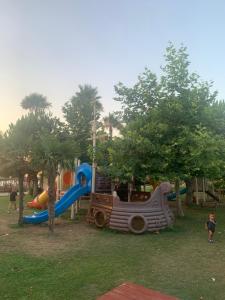a park with a playground with slides and trees at Seaview Apartments in Vlorë