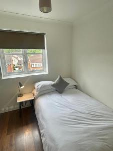 a small bedroom with a bed and a window at Modern 2 bedroom apartment near Glasgow Airport in Paisley