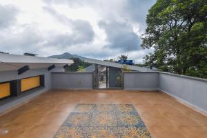 an empty balcony of a house with a patio at Castle Rock Villa By Tropicana Stays in Lonavala