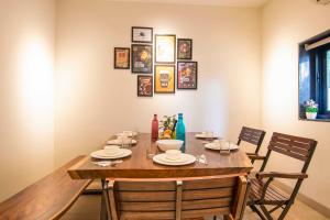 a dining room table with chairs and a wooden tableablish at Castle Rock Villa By Tropicana Stays in Lonavala