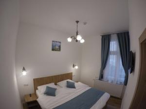 een slaapkamer met een bed met blauwe kussens en een raam bij Casa Bacila in Sibiu