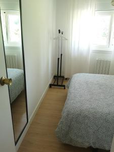 een slaapkamer met een spiegel naast een bed bij Apartamento Castelo de Santa Cruz in Oleiros