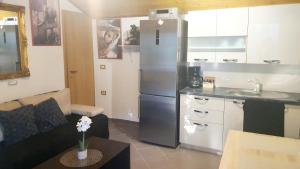 a kitchen with a stainless steel refrigerator in a living room at Little Brioni in Sečovlje