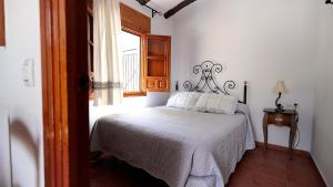 1 dormitorio con cama y ventana en Aparthotel El Cañuelo, en Monturque