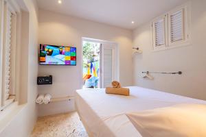 a bedroom with a white bed with a teddy bear on it at Wynwood Boutique Hotel in Willemstad