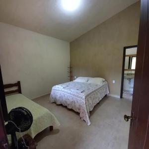 a bedroom with a bed and a mirror at Pousada Recanto do Sossego- Serra da Canastra in Vargem Bonita