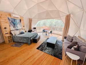 a living room with a bed and a couch in a tent at Broad River Campground Cabins & Domes in Boiling Springs