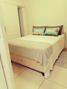 a small bed in a room with a white wall at Cabanas Del Mar in Warner Beach