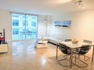 een woonkamer met een bank en een tafel bij Fully Renovated One Bedroom Apartment @ The Club in Miami