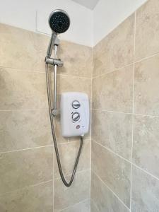 a shower with a blow dryer in a bathroom at Modern 2 bedroom apartment near Glasgow Airport in Paisley