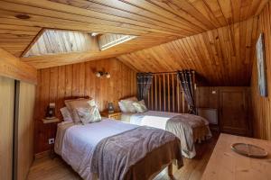 sypialnia z 2 łóżkami w drewnianym domku w obiekcie La Cabane du Petit Tour w mieście Langogne