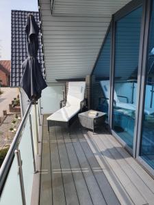 een balkon met een bed en een parasol bij Ferienwohnung Mühlenhof in Duderstadt