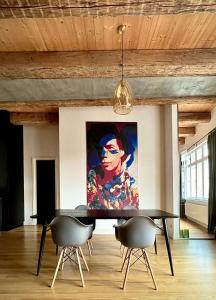 a painting on the wall of a room with a table and chairs at Boutique REZIDENCE BAAR in Nový Jičín
