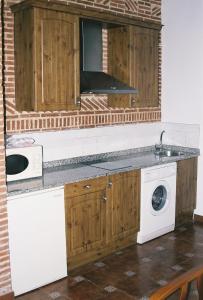 a kitchen with a sink and a washing machine at Las Cabañas de Pimiango in Colombres