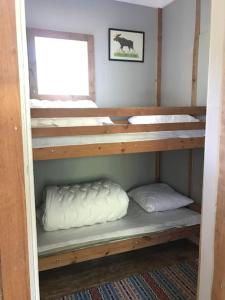 two bunk beds in a room with a window at Cozy Stuga - Mountain View in Ramsele