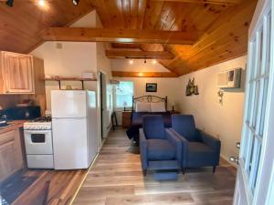 cocina con nevera y sillas azules en una habitación en Pine Grove Cottages, en Lincolnville