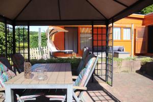 a patio with a table and chairs under a tent at Veluwe Park Reewold Chalet Eclipse in Putten
