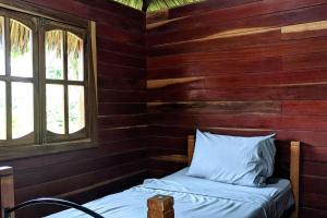 uma cama num chalé de madeira com uma janela em Wood Cabin - Cabana Maderas em Balgue