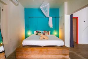 a bedroom with a bed with a blue wall at Wynwood Boutique Hotel in Willemstad