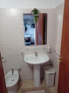 uma casa de banho com um lavatório, um WC e um espelho. em oasi macerina em Alanno
