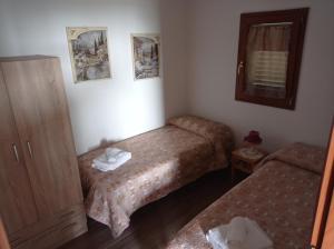 um pequeno quarto com 2 camas e um espelho em oasi macerina em Alanno