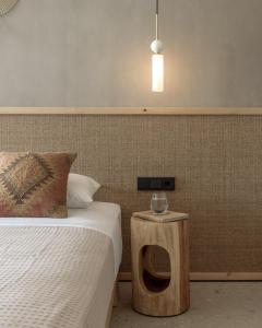 a bedroom with a bed and a night stand next to a bed at NERĒA Boutique Hotel in Plakias