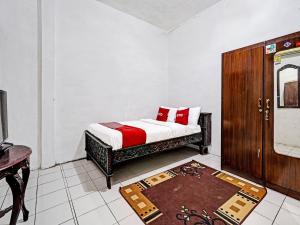 LebakwangiにあるOYO 91389 Anggrek Residence Syariahのベッドルーム1室(ベッド1台付)、木製キャビネットが備わります。