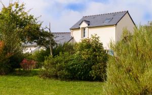 a small house in a grassy area next to a tree at Lagrange Vacances Le Hameau De Peemor Pen in Crozon