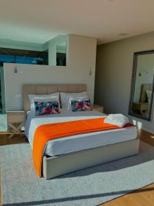 a bedroom with a large bed with an orange blanket at Oak Nature in Vieira do Minho